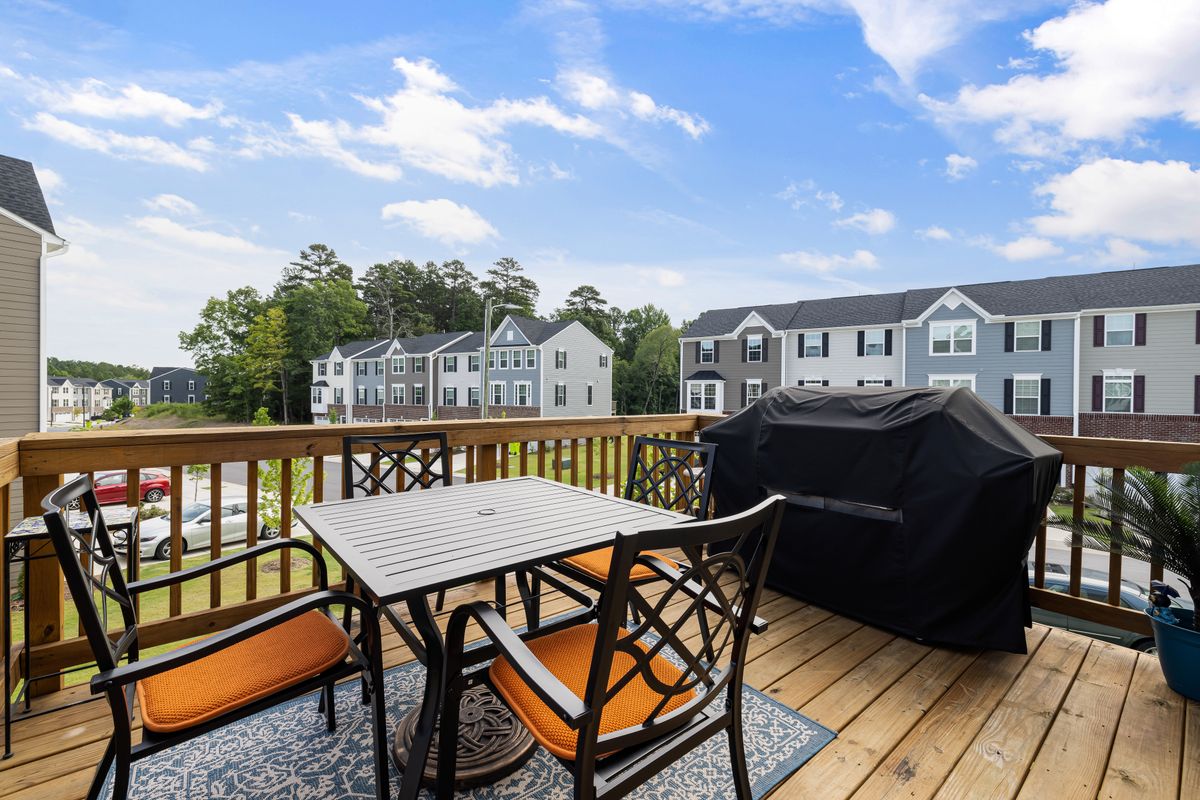 Outdoor dining table and metal chairs on a wooden deck
